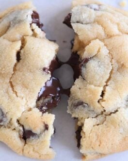 super soft chocolate chip cookie broken in half with melted chocolate chips