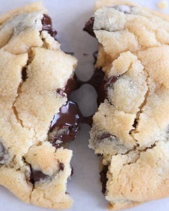 super soft chocolate chip cookie broken in half with melted chocolate chips