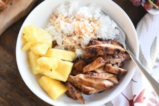 top down view of grilled teriyaki chicken in white bowl with rice and pineapple