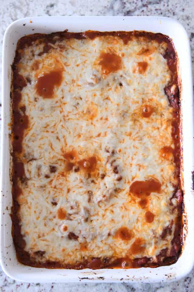 Baked cheesy zucchini casserole in white dish.