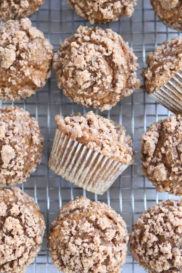 Several pumpkin snickerdoodle muffins on cooling rack.