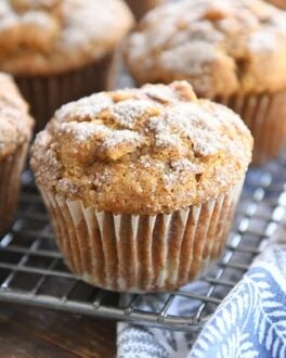 Baked muffins with cinnamon and sugar topping on cooling rack.