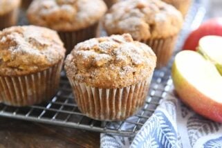 Baked muffins with cinnamon and sugar topping on cooling rack.