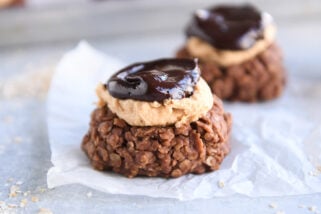 No bake cookie with peanut butter frosting and ganache on white parchment paper.