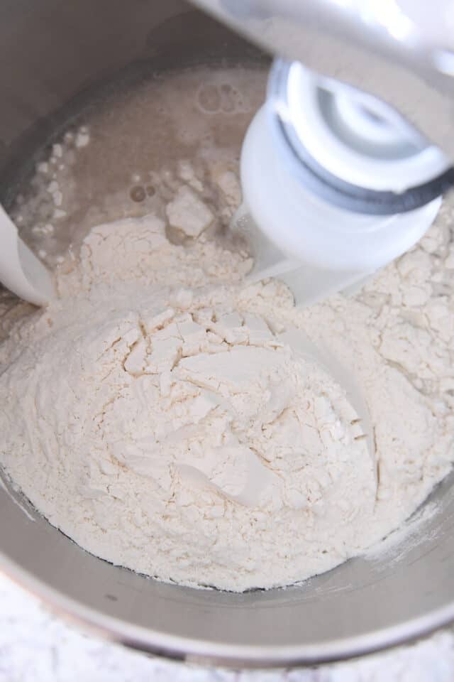 Flour, water, yeast in stainless steel mixing bowl.