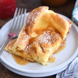 Square of golden German pancake on white plate.