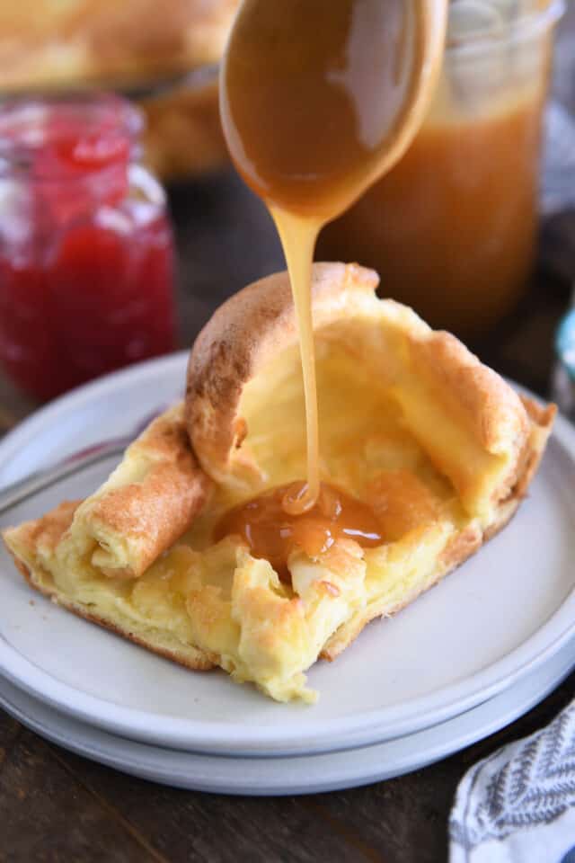 Drizzling caramel syrup over square of German pancake.
