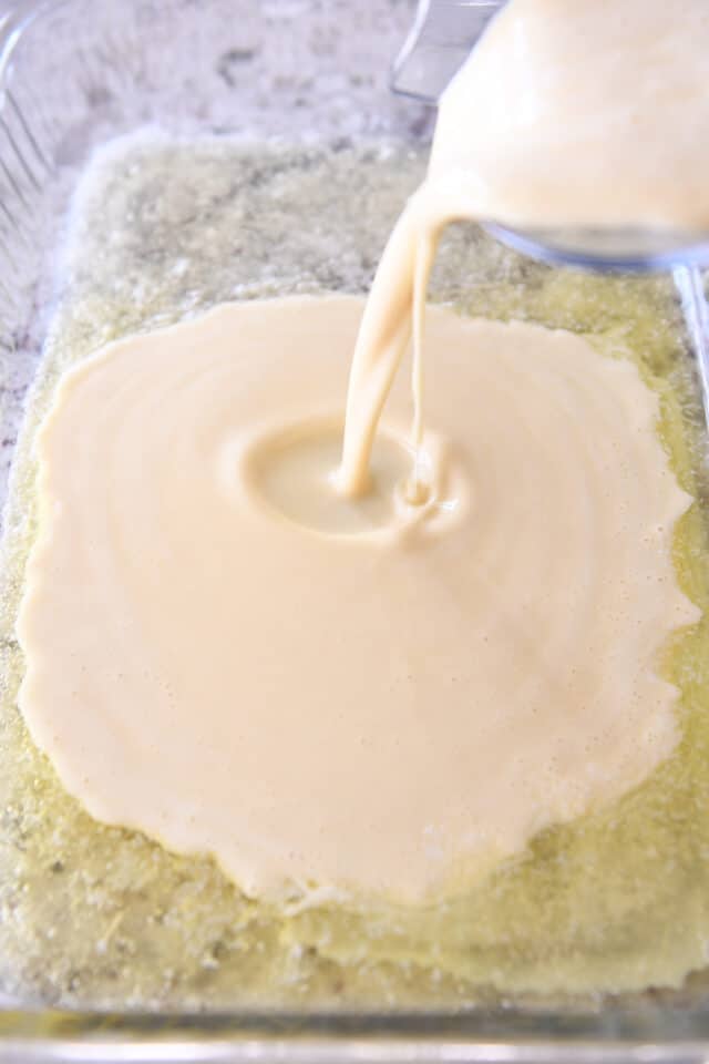 Pouring German pancake batter in buttered 9X13-inch dish.
