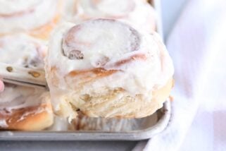 Frosted cinnamon roll on spatula.