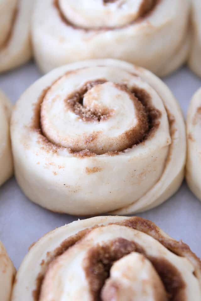 Unbaked cinnamon roll on sheet pan.