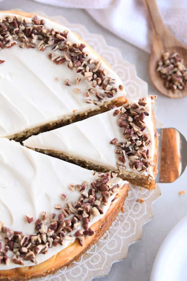 Triangle slice of carrot cake cheesecake on cake server.