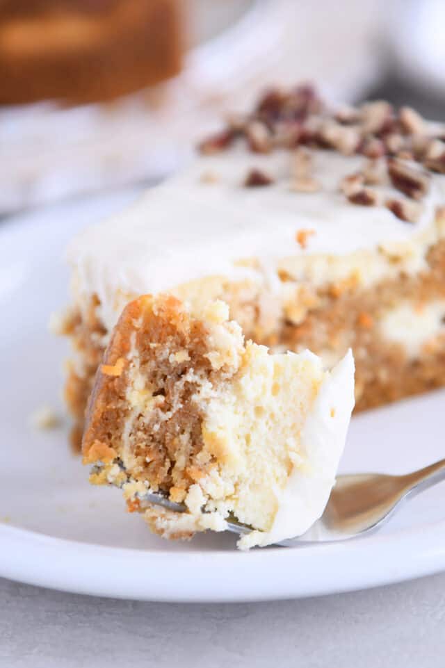 Bite of carrot cake cheesecake on fork.