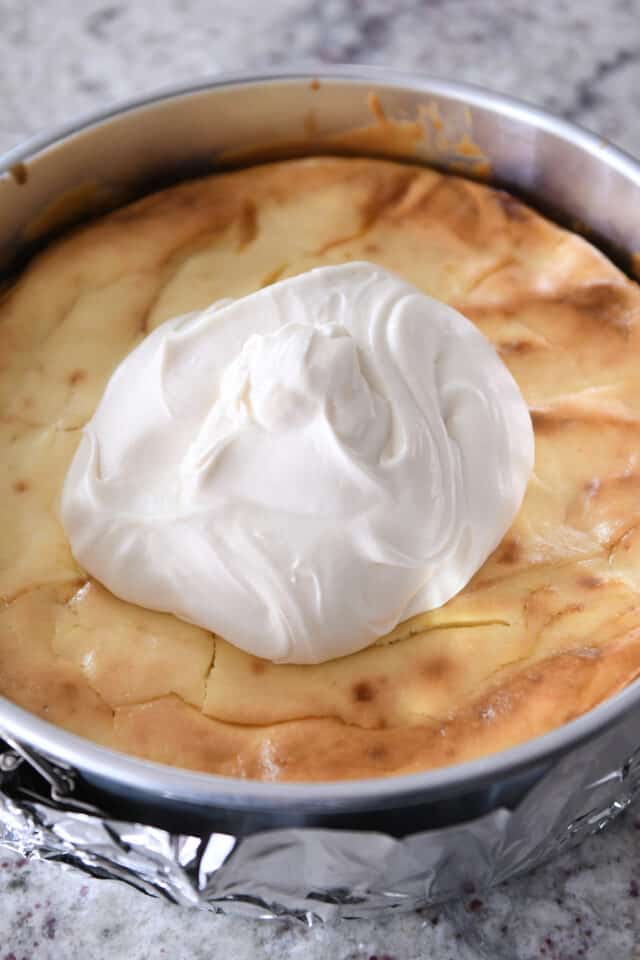 Dollop of cream cheese frosting on baked cheesecake.