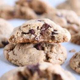 Half cookie stacked on top of whole cookie on parchment lined baking sheet.