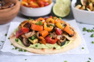 Flatbread topped with creamy avocado sauce and roasted vegetables.