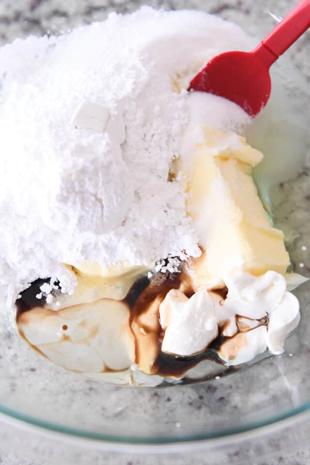 Glass bowl with butter, powdered sugar, granulated sugar, sour cream and vanilla.