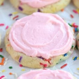 Pressed sugar cookie with sprinkles and pink frosting.