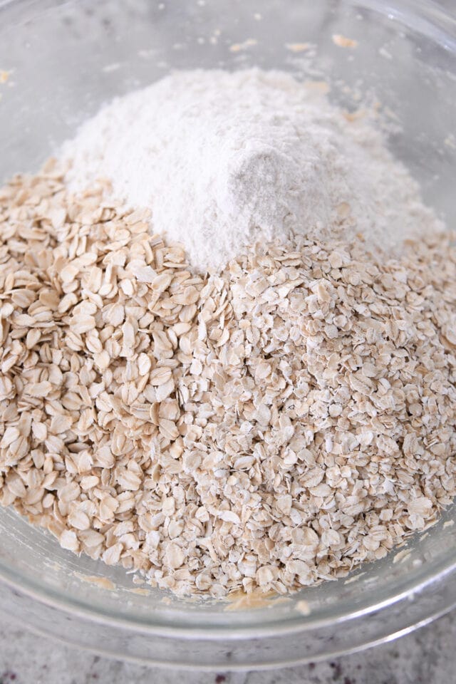 Glass bowl with flour, quick oats and old-fashioned oats.