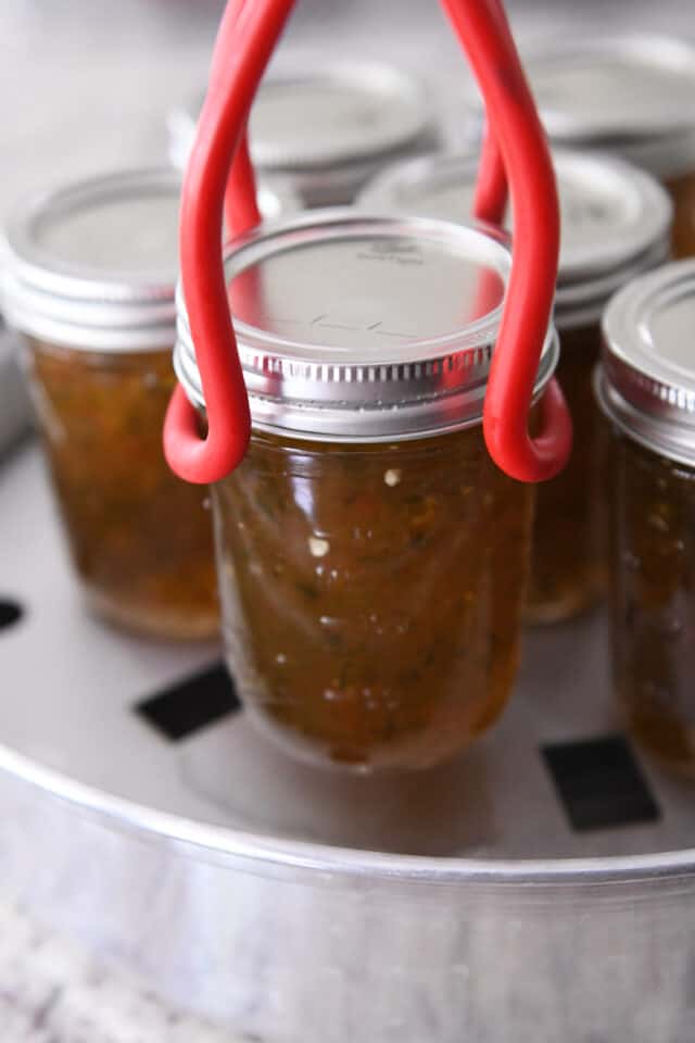 Lifting jar of jelly from steam bath canner.