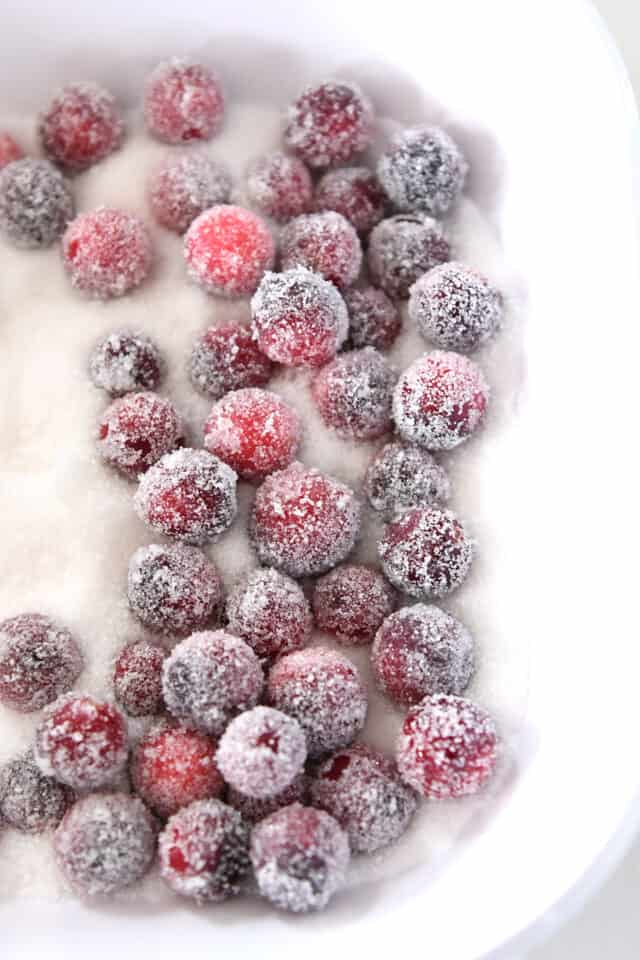 Cranberries rolled in sugar in white dish.
