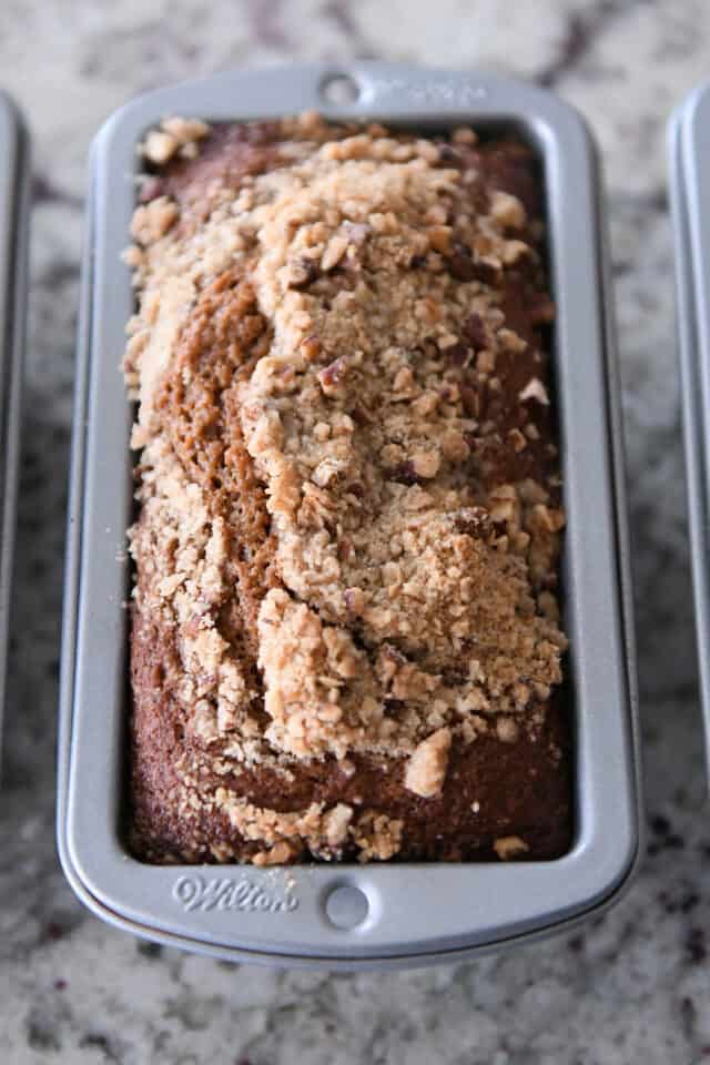 Mini loaf pan with baked gingerbread loaf and streusel.