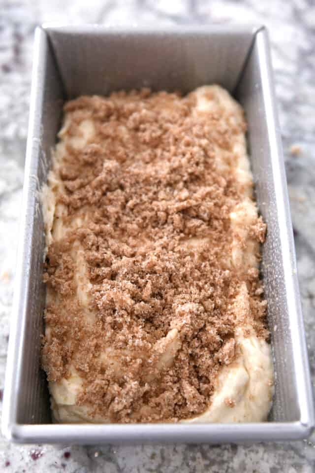 Banana bread batter in bread pan with sweet cinnamon topping.