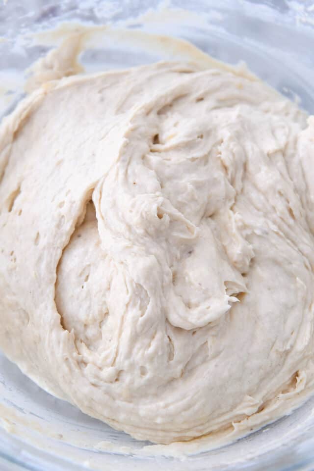 Thick and creamy banana bread batter in glass bowl.