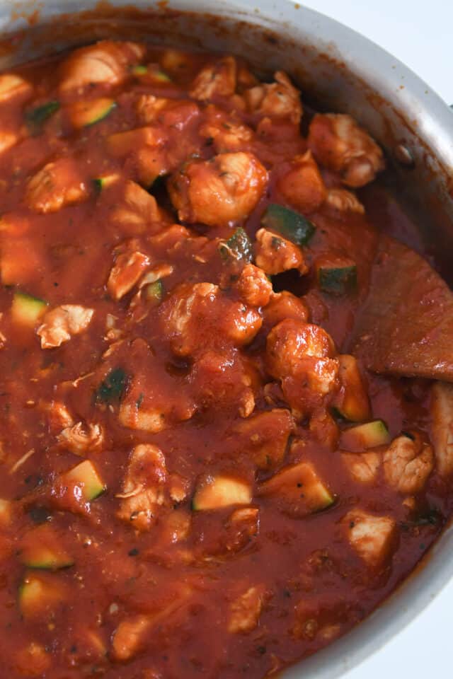 Skillet with zucchini, chicken and crushed tomatoes.