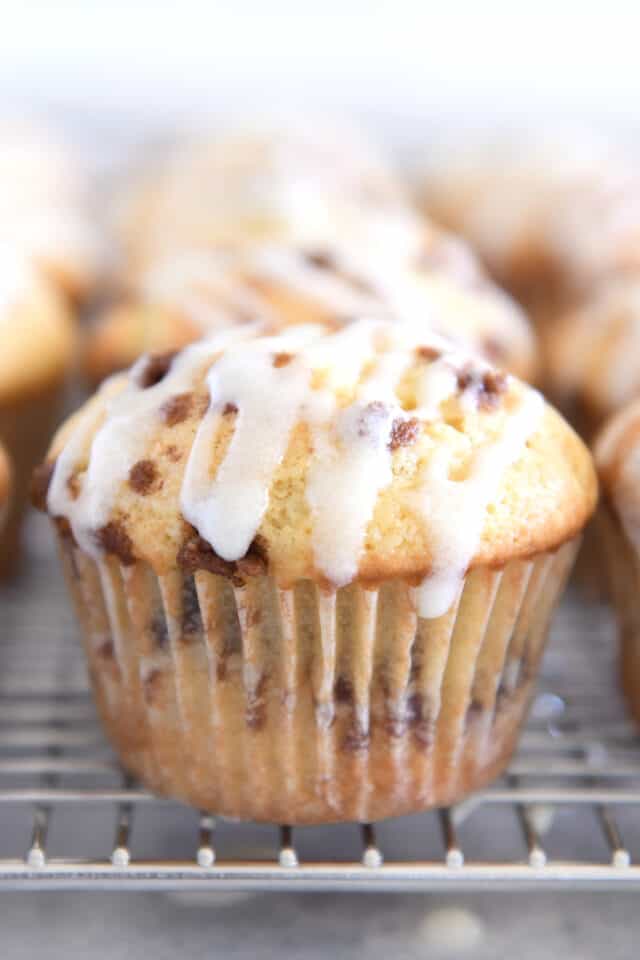 Glazed cinnamon roll muffin on cooling rack.