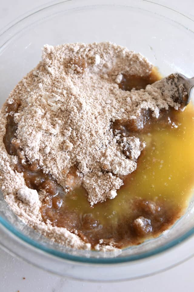 Melted butter added to dry ingredients in glass bowl.