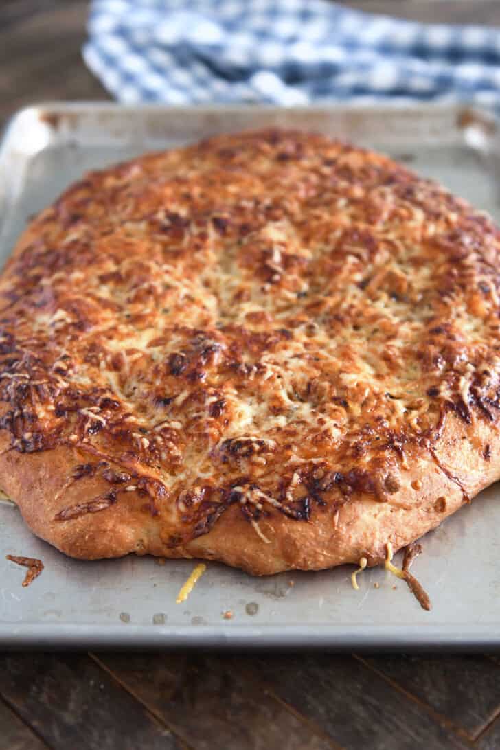 Baked Italian cheese bread on half sheet pan.