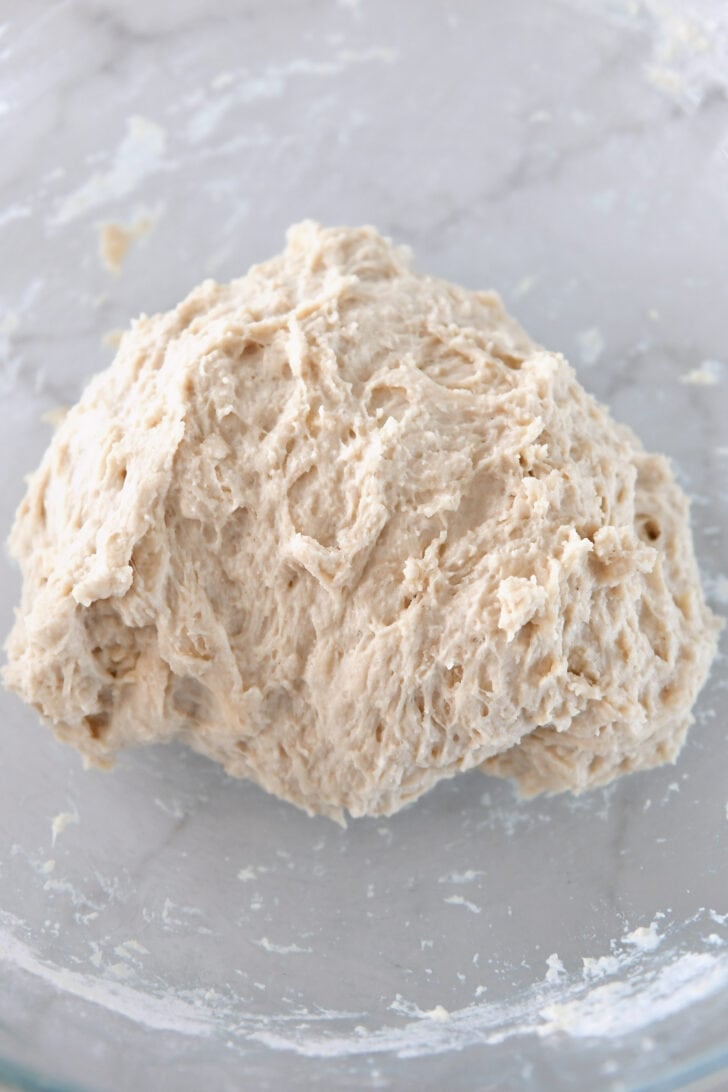 Glass bowl with hand-mixed bread dough.