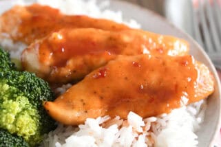 Gray plate with rice and saucy chicken tenders.