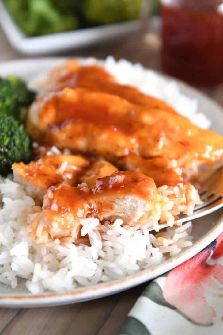 Chicken cut in pieces with chili garlic sauce and rice.