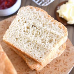 Slice of English muffin bread on wood cutting board.