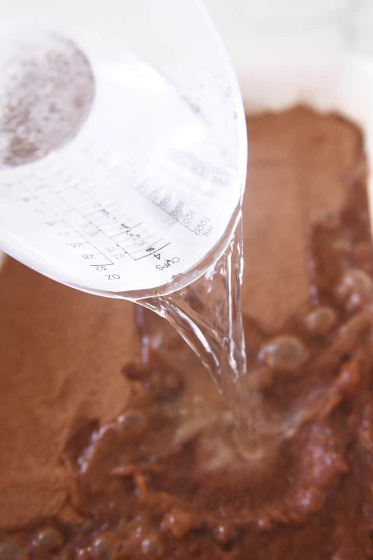 Pouring boiling water over cake batter.