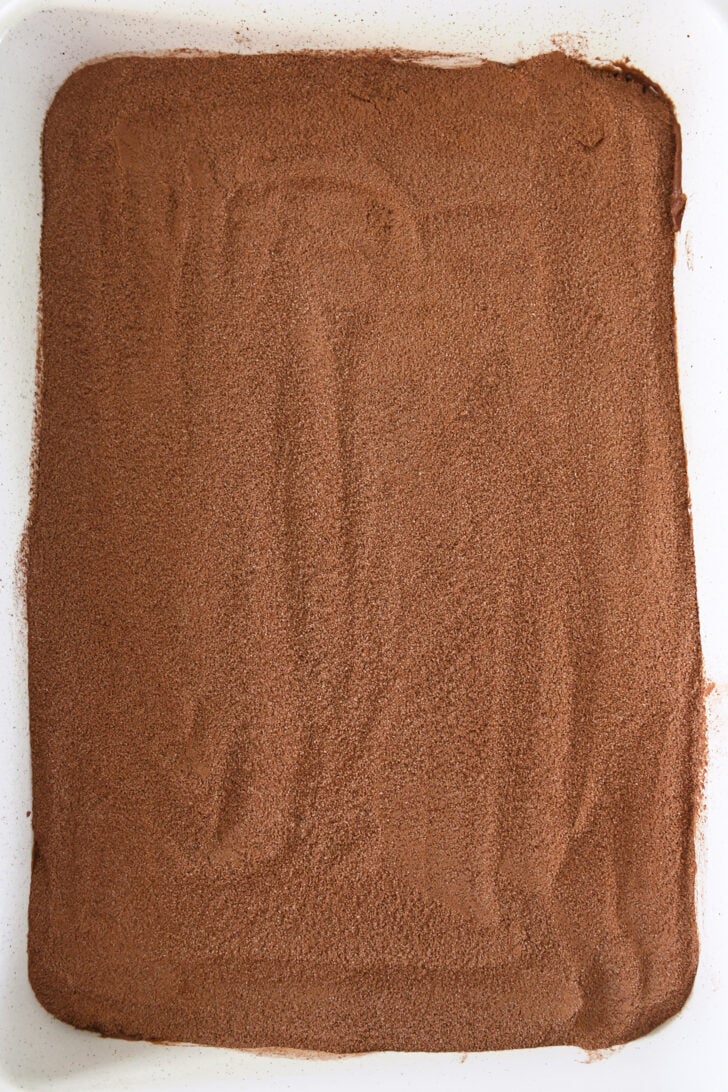 Sugar and cocoa mixture spread over chocolate cake batter in white 9X13-inch pan.