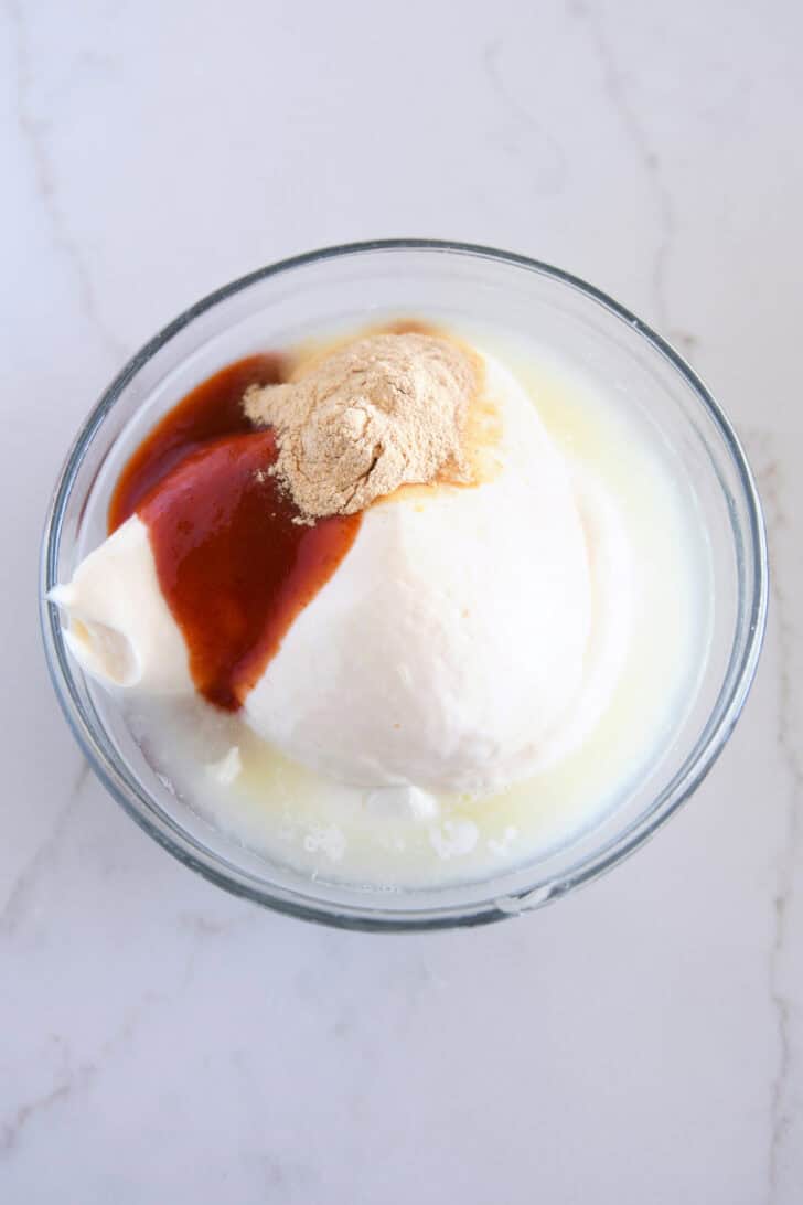 Small glass bowl with sour cream, mayo, garlic powder and sriracha.