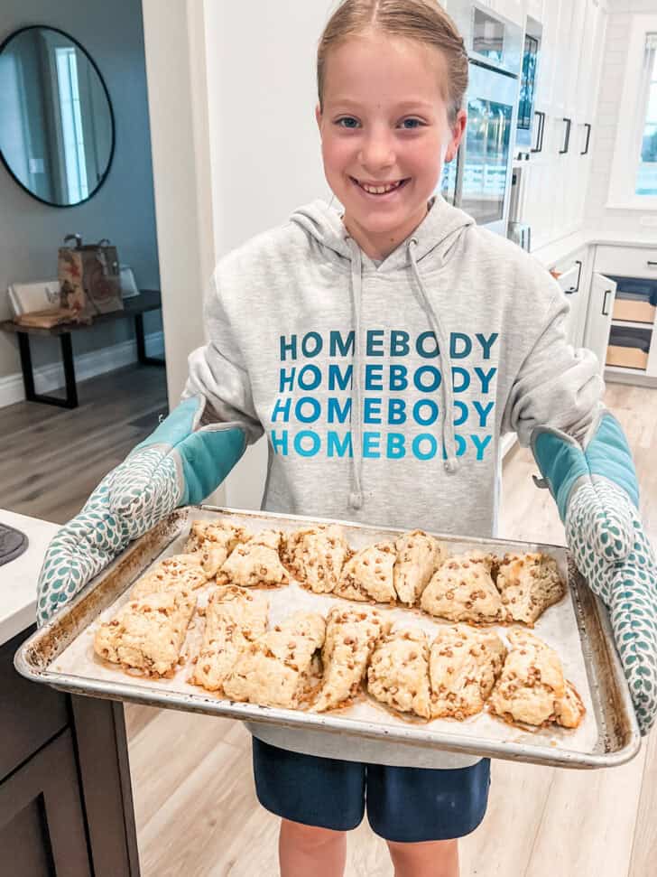 Girl holding tray of scones.