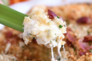 Creamy cheesy bacon dip on piece of celery.