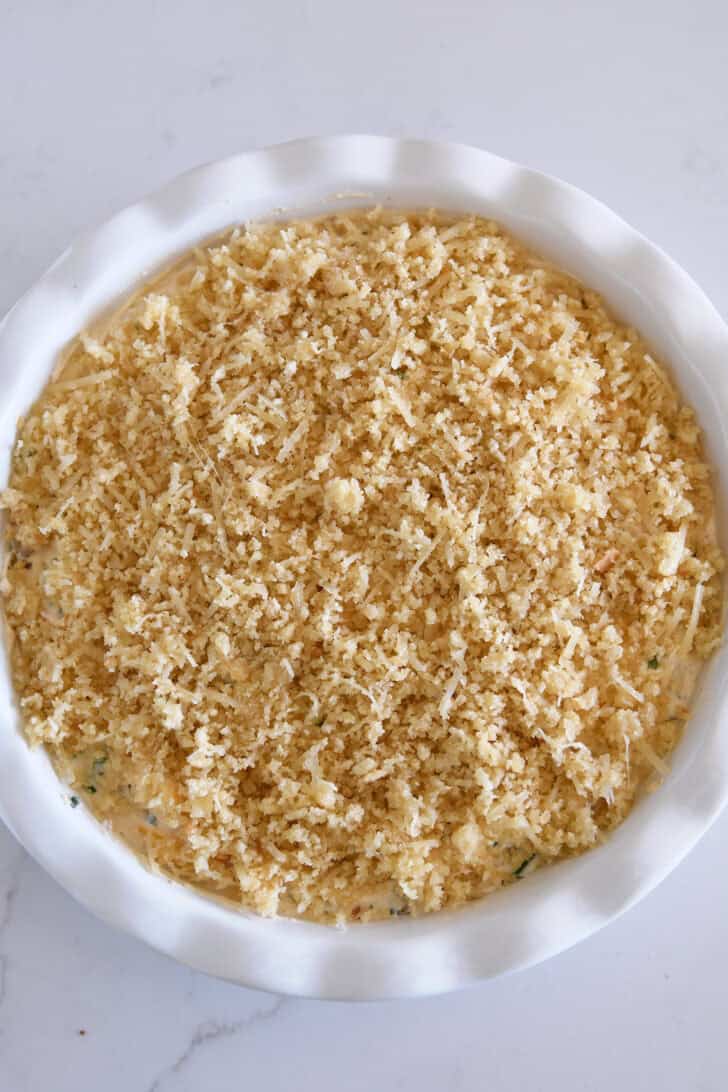 Top down view of unbaked jalapeno popper dip in white pie plate.