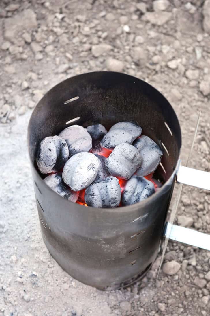 Chimney starter filled with hot coals/briquettes.