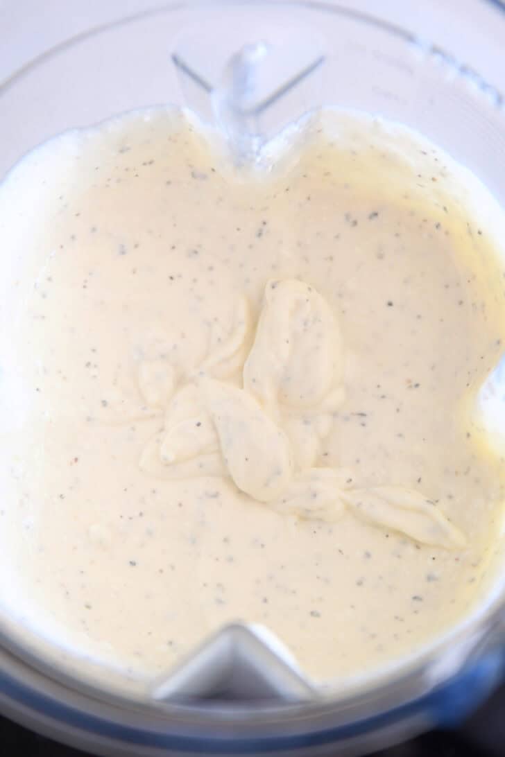 Blender with blended creamy mixture of cottage cheese and eggs.
