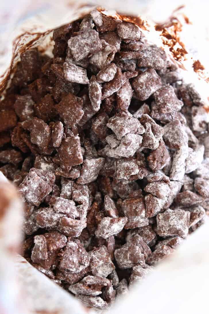 Peanut butter and chocolate coated chex cereal with powdered sugar in ziploc bag.
