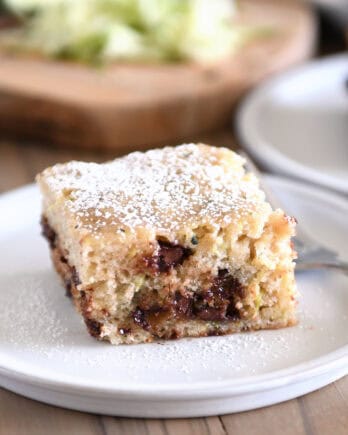 Square piece of zucchini chocolate chip cake on gray plate.