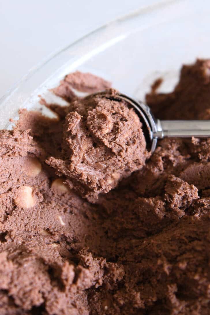 Cookie scoop scooping portion of chocolate peanut butter chip cookie dough.