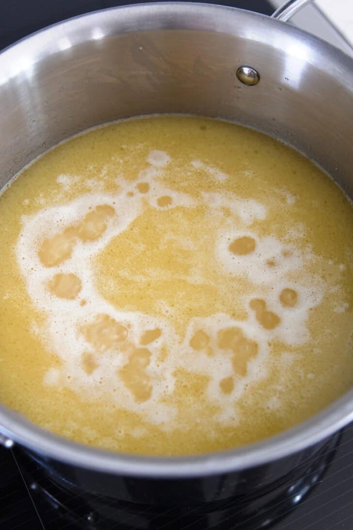 Chicken broth simmering in pan with rice.