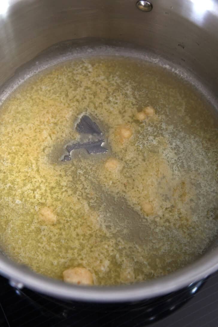 Butter and garlic simmering in stainless pot.