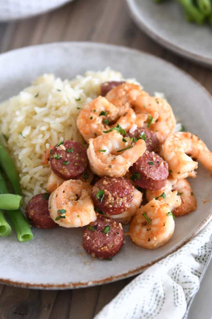 Gray stone plate with rice, shrimp and sausage.