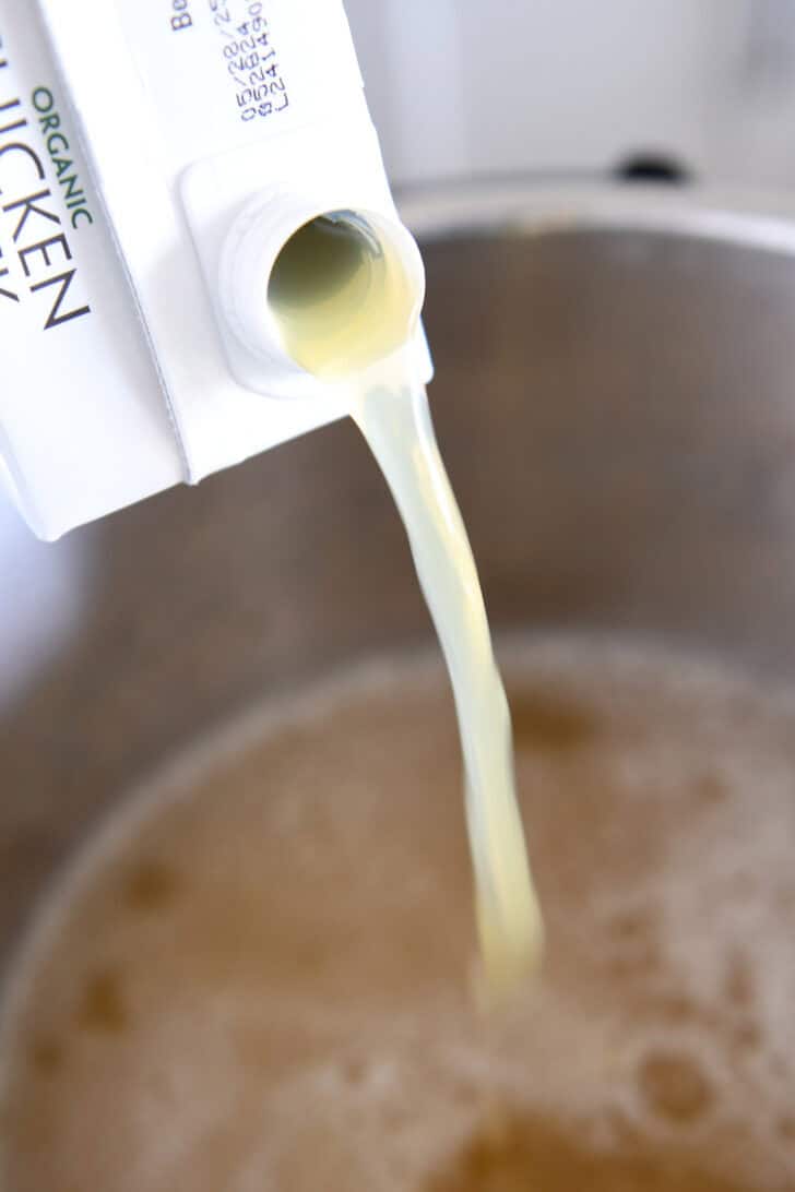 Pouring chicken broth into Instant Pot.